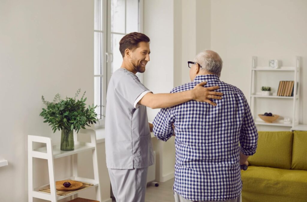 A male caregiver helping a male with parkinsons to walk  