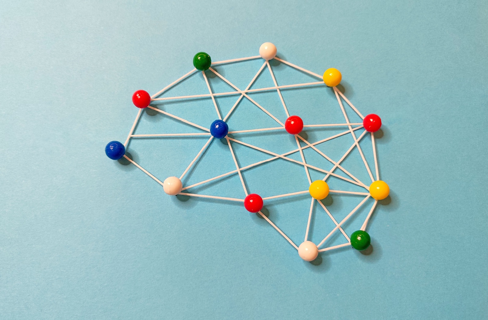 A diagram of the brain made with small balls and string to represent dementia.